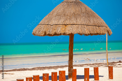 Fototapeta Naklejka Na Ścianę i Meble -  Big straw umbrella at the white sand beach