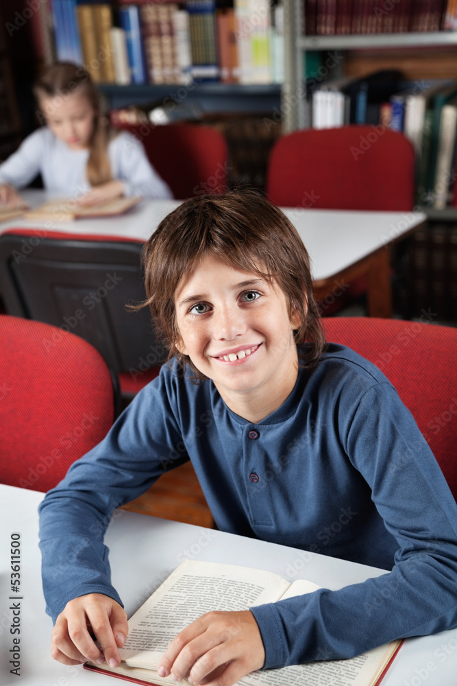 Schoolboy With Book Sitting In Library Schoolboy With Book Sitting In Library