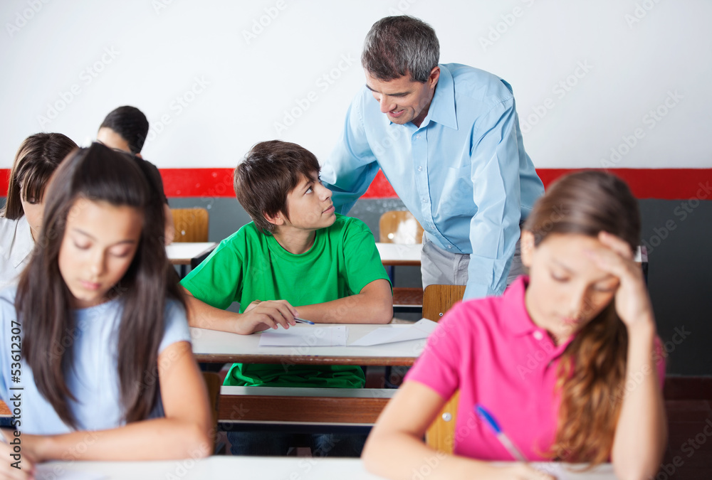 Professor And Teenage Student Looking At Each Other During Exami Professor And Teenage Student Looking At Each Other During Exami