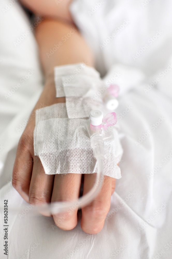 Mano di giovane donna con la flebo nel letto di ospedale Photos | Adobe  Stock