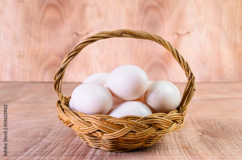 Fresh eggs in basket on wood background Fresh eggs in basket on wood background