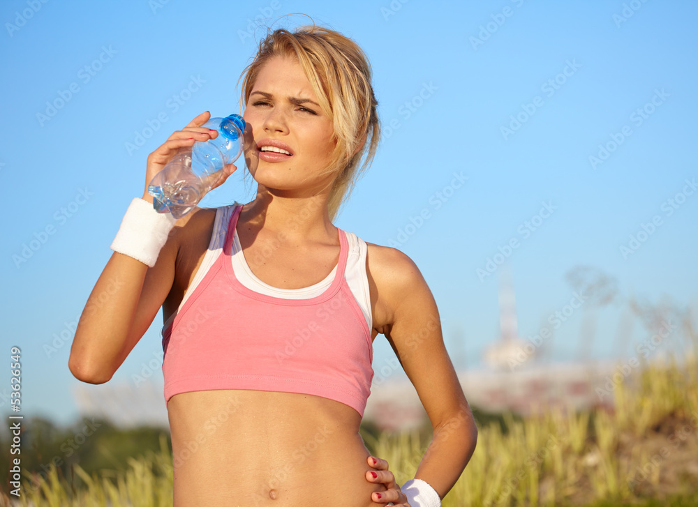cheerful young attractive woman drinking water, outdoors cheerful young attractive woman drinking water, outdoors