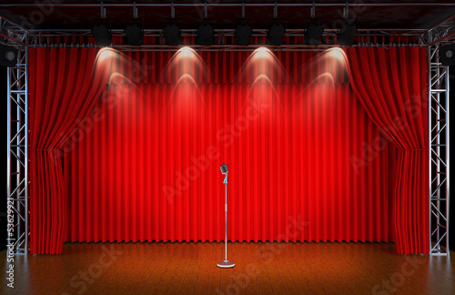 vintage microphone on Theater stage with red curtains and spotli