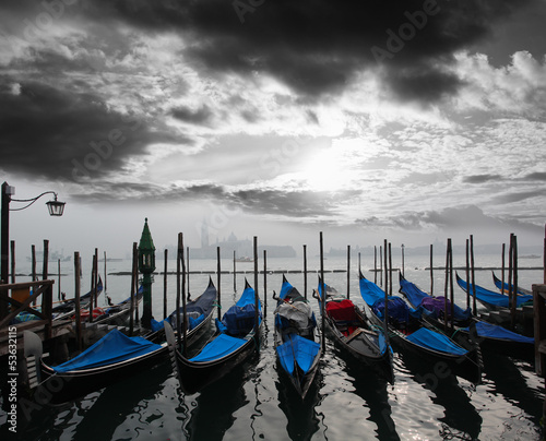 Venice with gondolas against sunrise in Italy