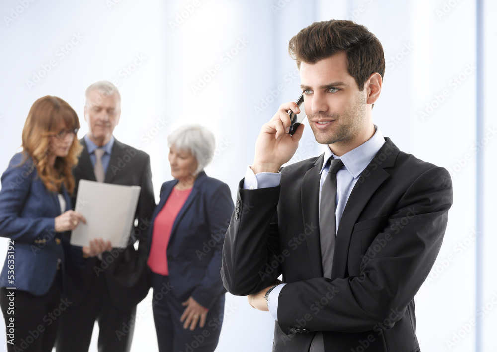 Smiling young businessman talking on mobile phone