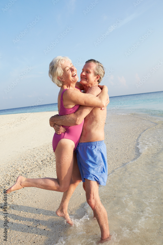 Senior Couple Having Fun On Tropical Beach Holiday