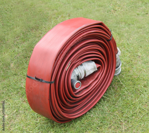 A Rubber Coated Large Coiled Red Fire Hose.