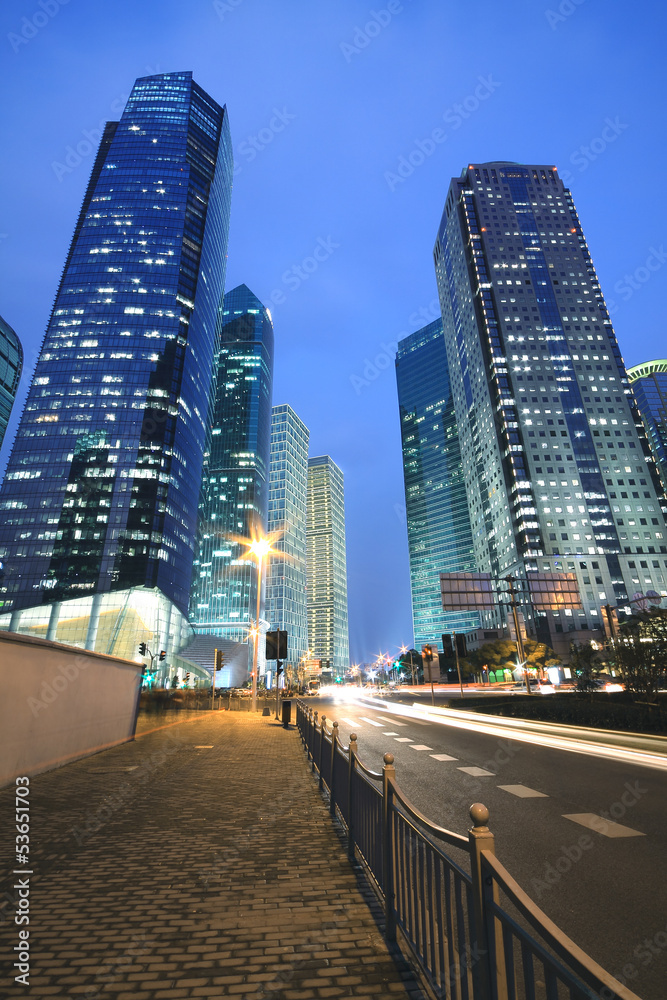 Fototapeta premium The light trails on modern office building background