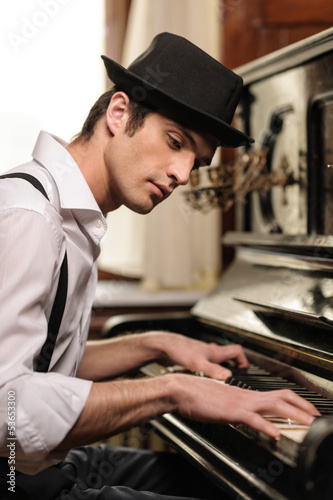 Cuadro en lienzo Virtuoso playing piano. Side view of handsome young men playing