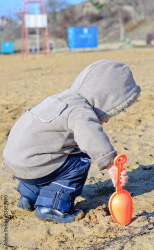 Young boy playing on the beach sand