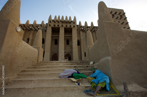 Sleepers in front of djenné mosque in Mali photo