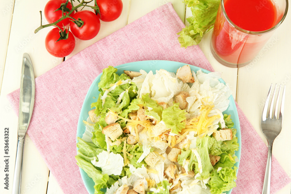 Caesar salad on blue plate, on color wooden background Caesar salad on blue plate, on color wooden background