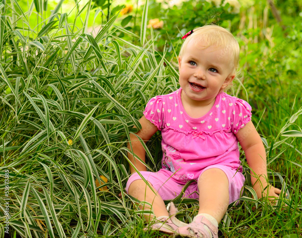 cute little girl sitting in the green grass cute little girl sitting in the green grass