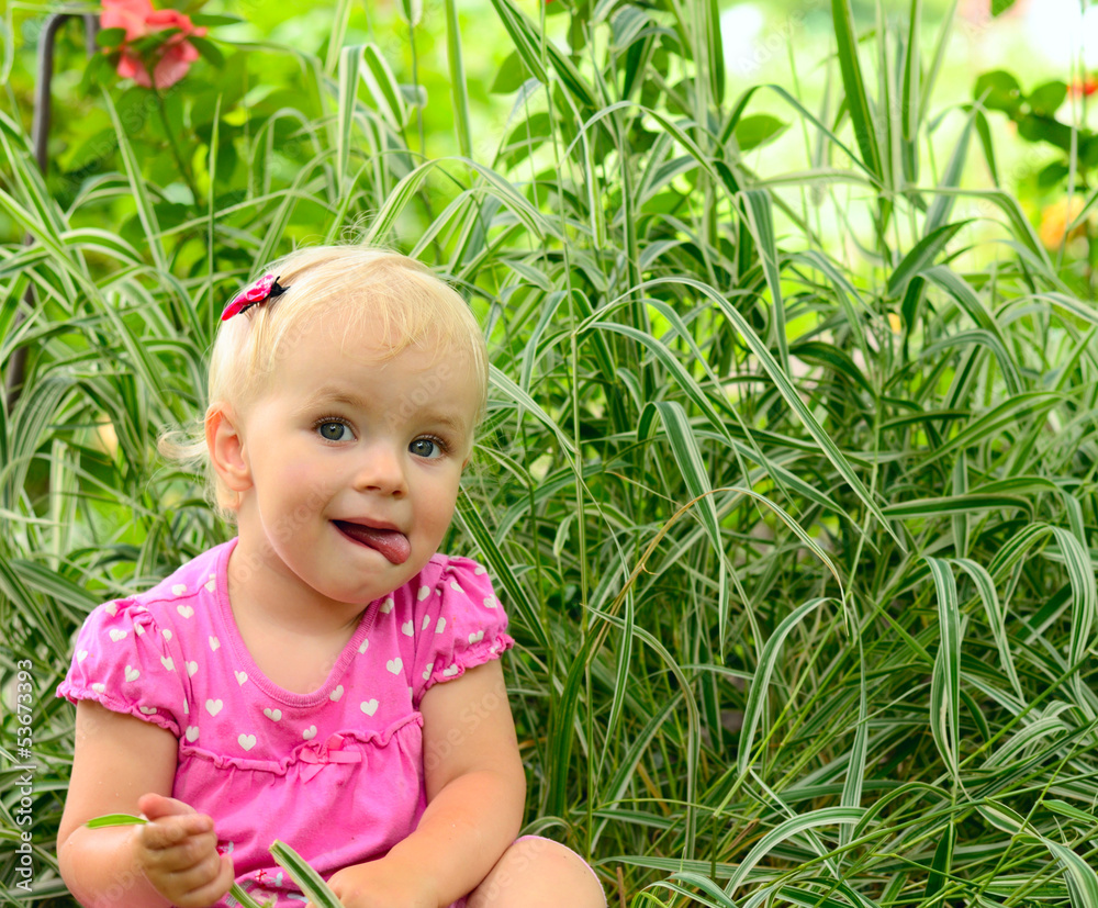 cute little girl sitting in the green grass cute little girl sitting in the green grass