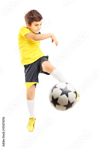 Full length portrait of a kid in sportswear shooting a ball