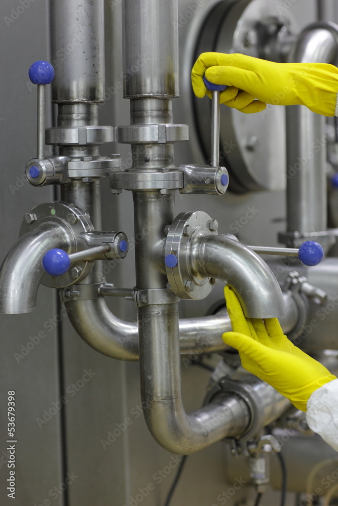 hands in yellow gloves on tap and lever of technological system hands in yellow gloves on tap and lever of technological system