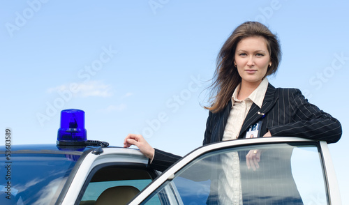 Obraz na płótnie Young female FBI agent standing near car open door
