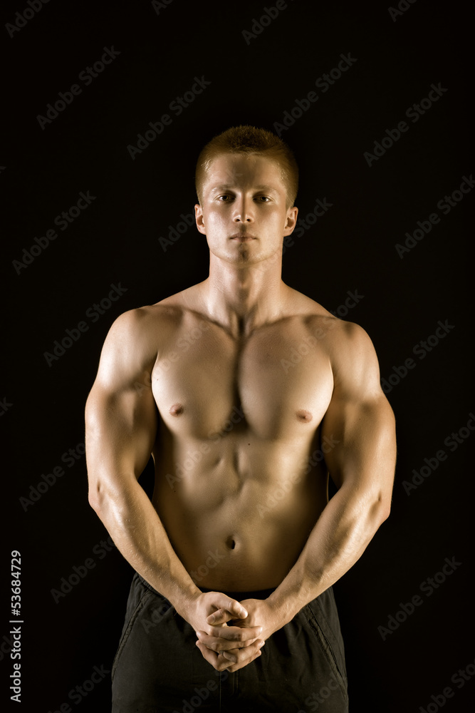Naklejka premium Healthy muscular young man posing in studio