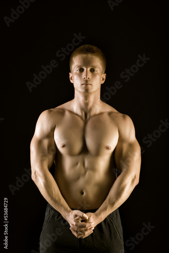 Healthy muscular young man posing in studio