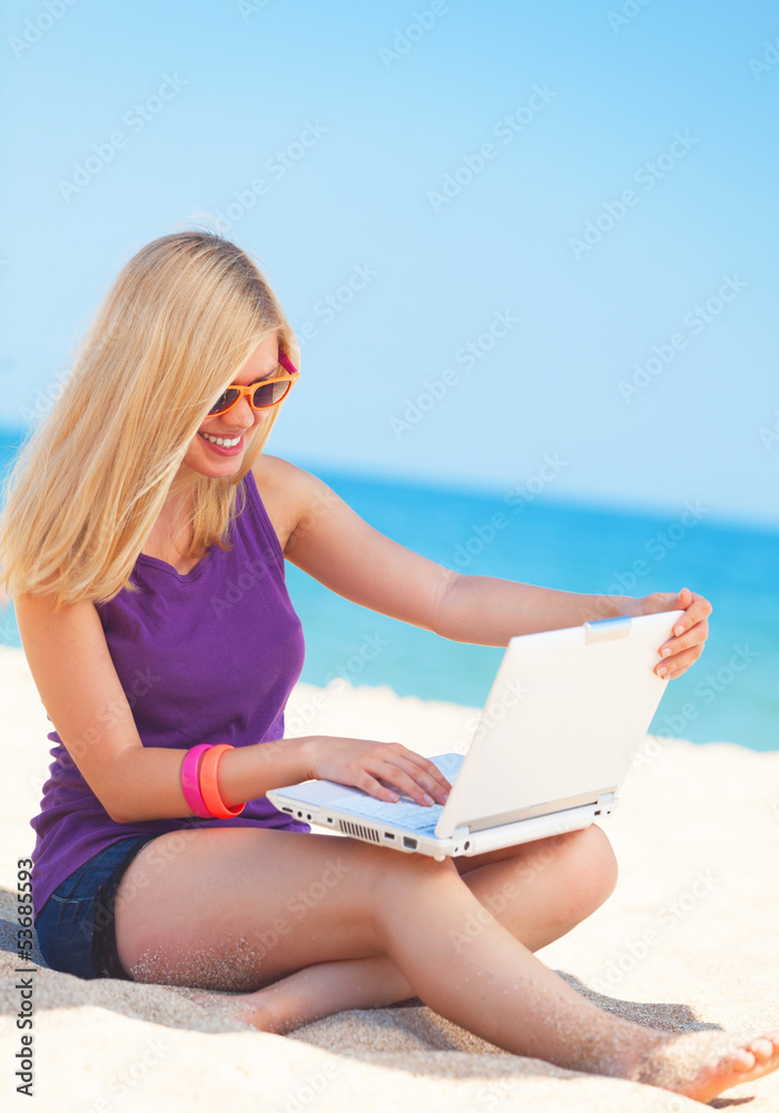 Blonde girl with notebook at the beach.