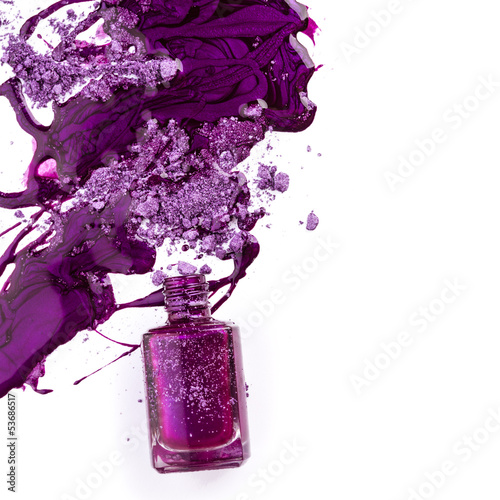 Purple nail polish and crushed eye shadow on white background photo