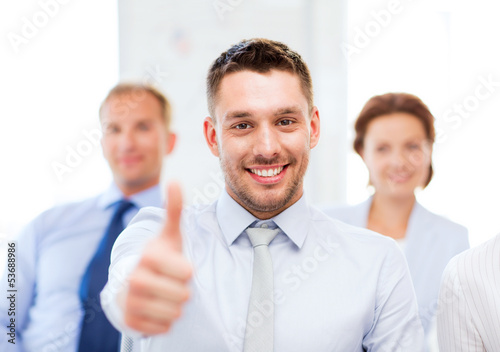 businessman in office showign thumbs up photo