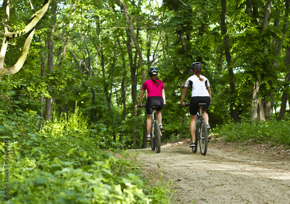 Obraz premium girls biking in the forest