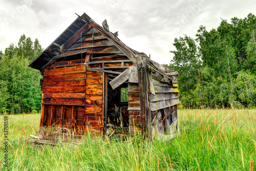 Abandoned wooden shed in a grass field
