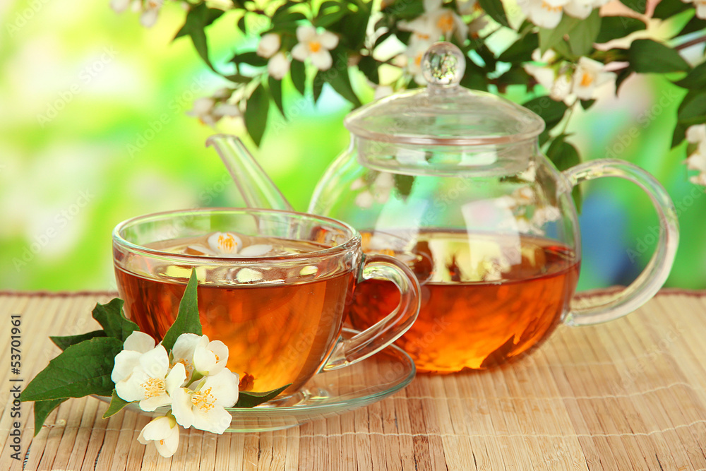 Cup of tea with jasmine, on bamboo mat, on bright background Cup of tea with jasmine, on bamboo mat, on bright background