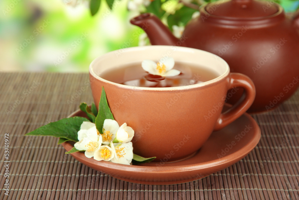 Cup of tea with jasmine, on bamboo mat, on bright background Cup of tea with jasmine, on bamboo mat, on bright background