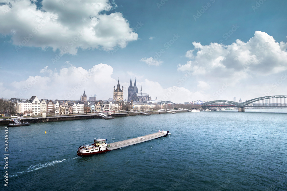 Cologne cityline with cargo ship on rhine