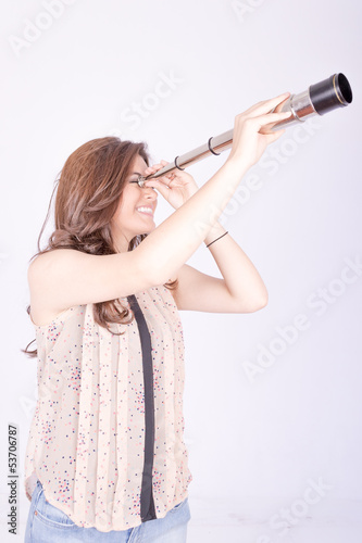 Young woman using telescope