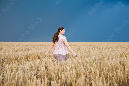 Young pregnant woman on wheat field