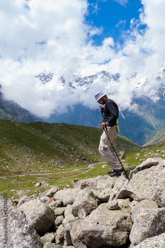 Hikier is jumping on rocks in Caucasus mountains in Bezengi regi