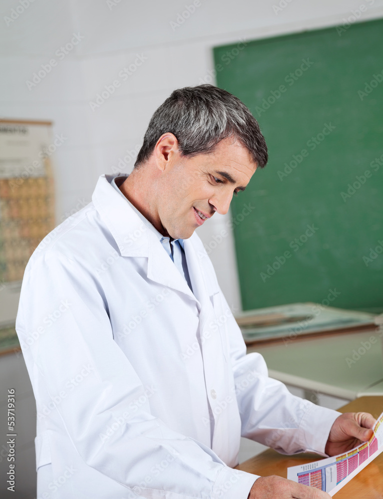 Professor Reading Paper At Desk In Lab