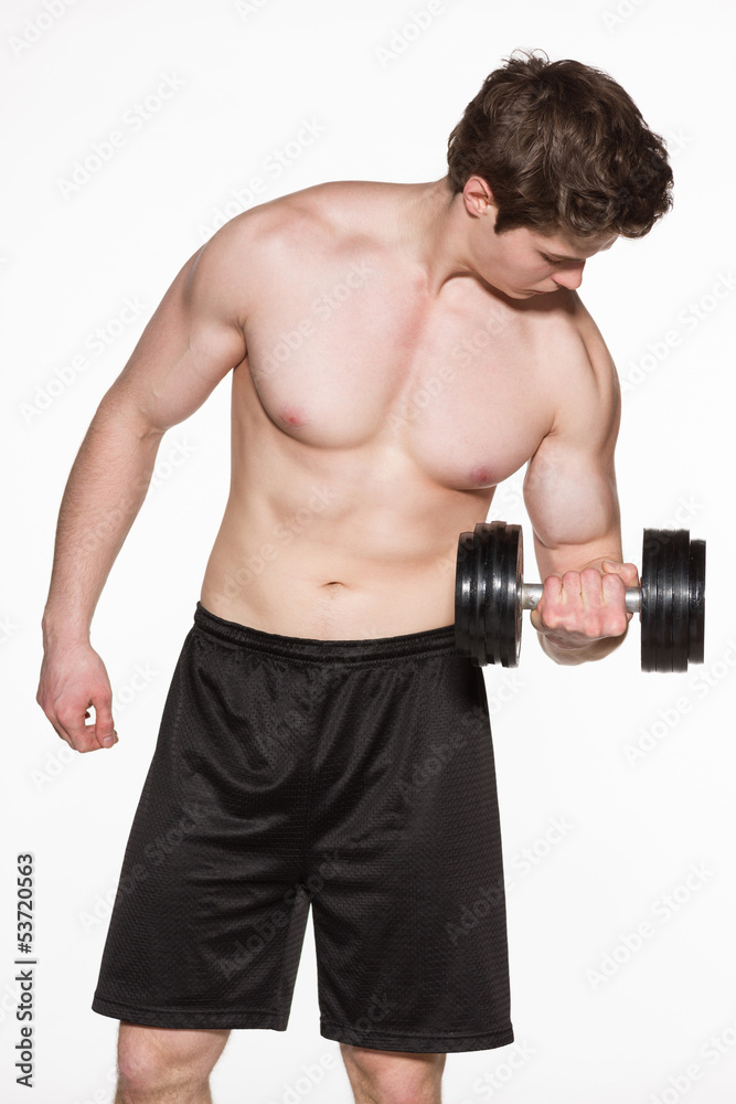 Muscular young man lifting a dumbbell over white