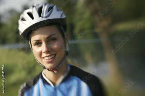 young woman training on mountain bike and cycling in park © Diego Cervo