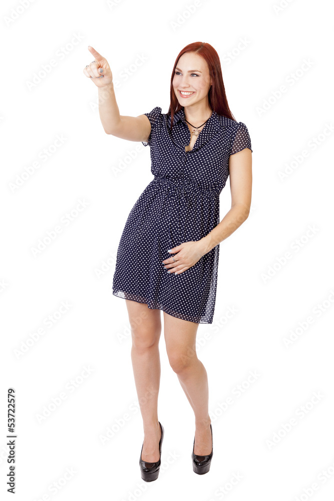 Attractive young lady points and smiles.