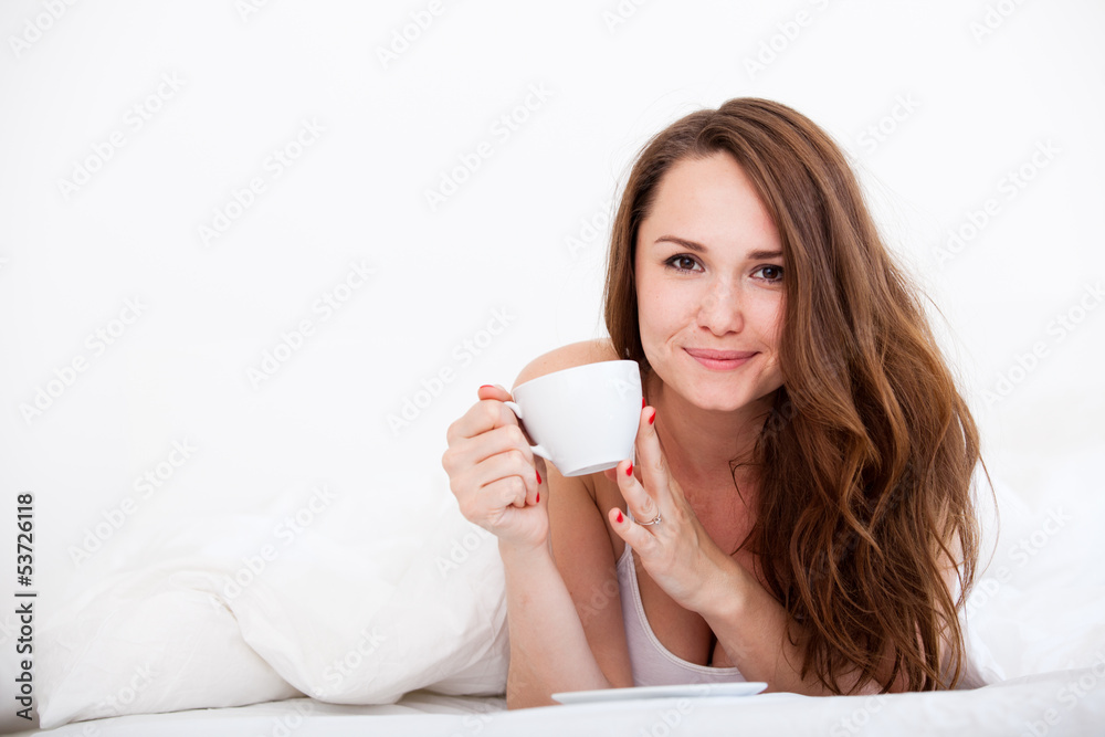 Woman in bed drinking tea