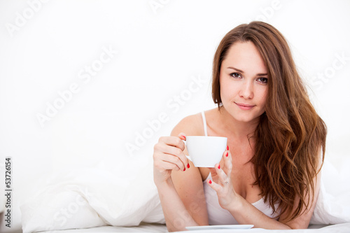Woman in bed drinking tea