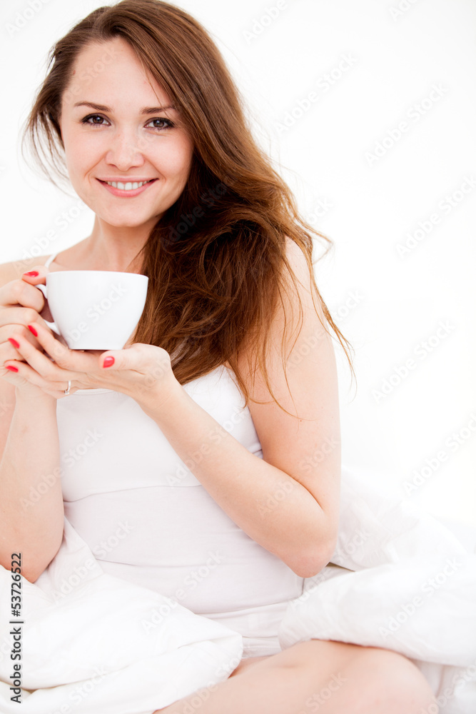 woman sitting on bed with cup woman sitting on bed with cup