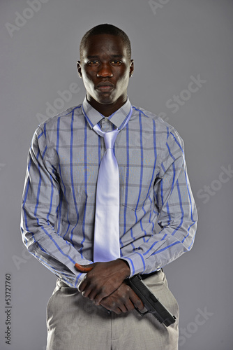 Man in shirt and tie holding a gun in his hands