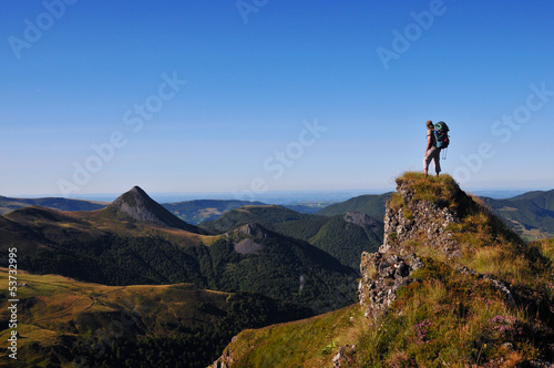 hiker on top of a rock looking far away photo