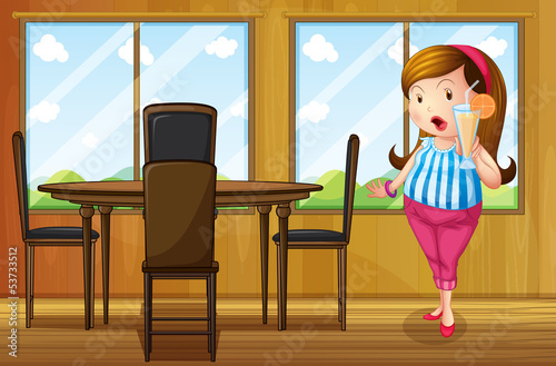 A fat girl holding a juice inside the house