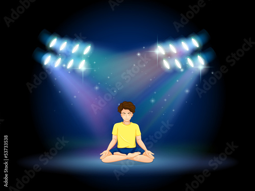 A stage with a man doing yoga