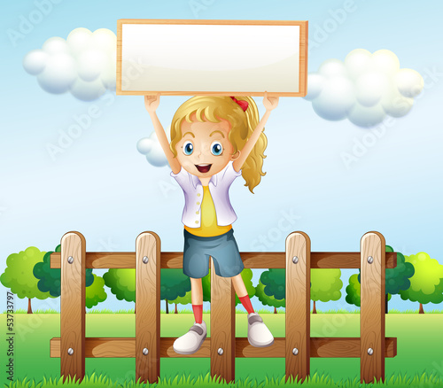 A girl holding an empty frame standing above the fence