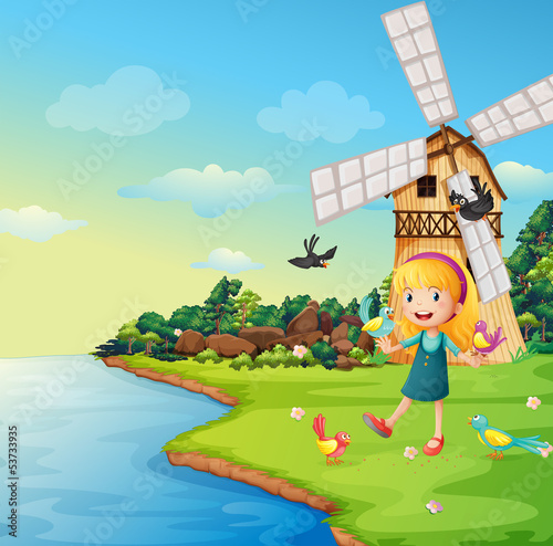 A girl playing with her birds near the barnhouse with windmill