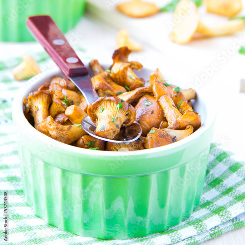 Fried autumn golden chanterelle mushrooms with herbs in cup