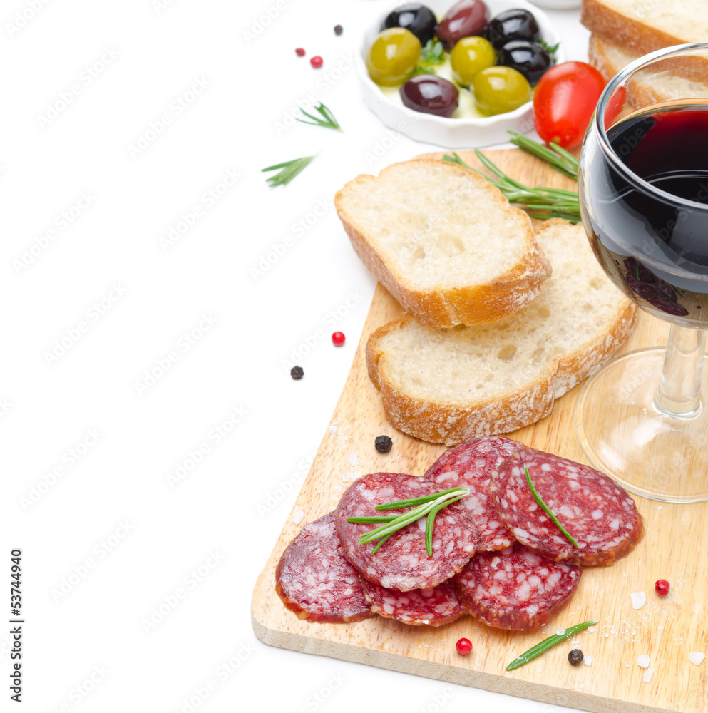 salami, bread, olives, glass of wine on wooden board isolated