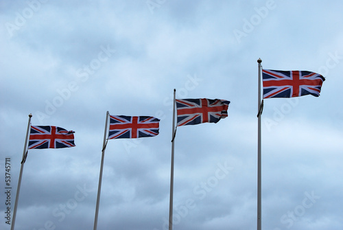 Four British Flags against Cloudy Sky